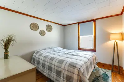 a bedroom with a bed and a table and a window at Year-Round Fun on Lake Sheridan! Home with Patio
