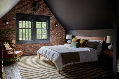 a bedroom with a bed and a brick wall at Eleanor Inn - Suite Lorena in Warwick