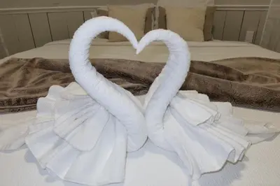 two towels in the shape of swans on a bed at Chic 2BR Retreat in Albany Cozy, Stylish & Central in Albany
