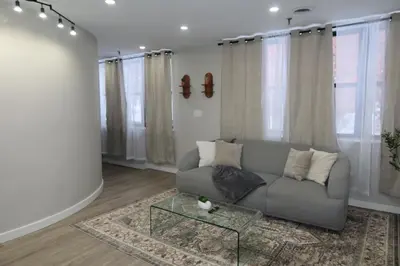 a living room with a couch and a glass table at Chic 2BR Retreat in Albany Cozy, Stylish & Central in Albany