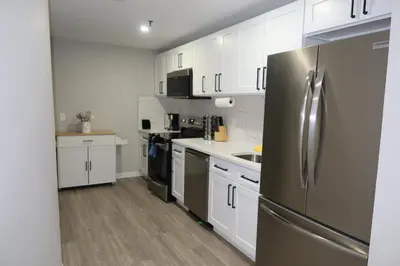 a kitchen with white cabinets and a stainless steel refrigerator at Chic 2BR Retreat in Albany Cozy, Stylish & Central in Albany