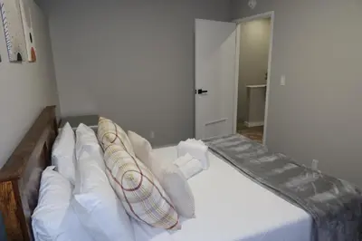 a bedroom with a bed with white pillows at Chic 2BR Retreat in Albany Cozy, Stylish & Central in Albany