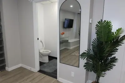a bathroom with a mirror and a toilet at Chic 2BR Retreat in Albany Cozy, Stylish & Central in Albany