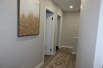 a hallway with a painting hanging on a wall at Chic 2BR Retreat in Albany Cozy, Stylish & Central in Albany