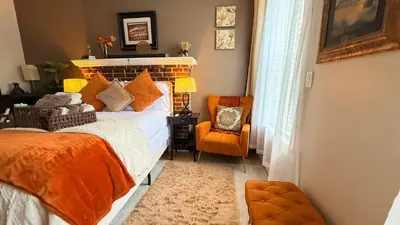 a bedroom with a bed and an orange chair at 2-Joint Large Deluxe Rooms in Private House - NYC in Sunnyside