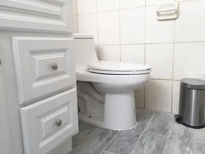 a white bathroom with a toilet and a trash can at 2-Joint Large Deluxe Rooms in Private House - NYC in Sunnyside