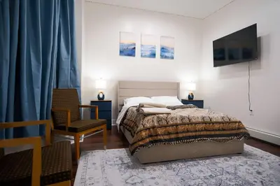 a bedroom with a bed and a tv and a chair at Stylish & Comfortable City Stay in West New York