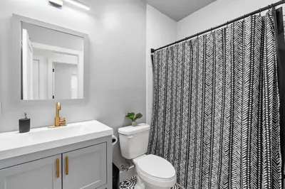 a bathroom with a toilet and a shower curtain at Premier 3BR-5BD-3Bath Retreat with NYC Access in Jersey City