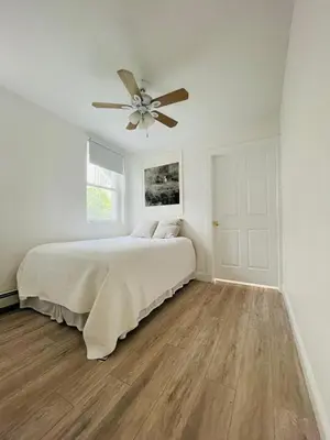 a bedroom with a bed and a ceiling fan at 2 Bedroom Garden Apartment Near Journal Square - Prime World Cup Lodging in Jersey City