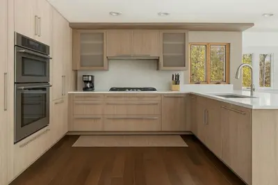 a kitchen with wooden cabinets and white counter tops at Drift Haus 4 and half BR Mountain Lodge in Windham