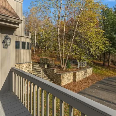 a porch of a house with a fence and a tree at Drift Haus 4 and half BR Mountain Lodge in Windham