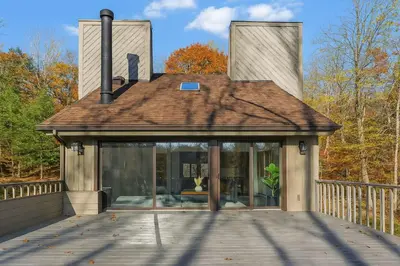 a house with glass doors on a wooden deck at Drift Haus 4 and half BR Mountain Lodge in Windham