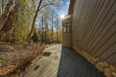a house with a wooden deck next to a building at Drift Haus 4 and half BR Mountain Lodge in Windham