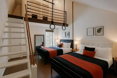 a bedroom with two beds and a staircase at Drift Haus 4 and half BR Mountain Lodge in Windham