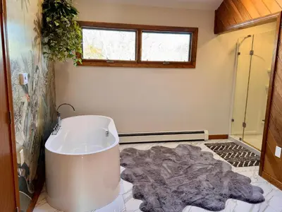 a bath tub in a bathroom with a rug at Spacious 4BR Near Beaches WFH Office & Pool in Guilford