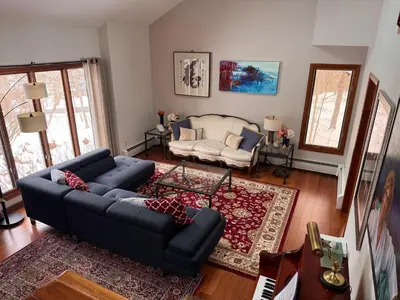 a living room with a blue couch and a chair at Spacious 4BR Near Beaches WFH Office & Pool in Guilford