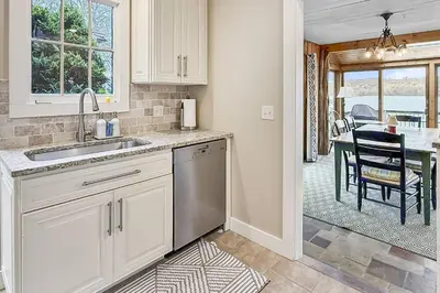 a kitchen with a sink and a dining room with a table at Candlewood Isle in New Fairfield