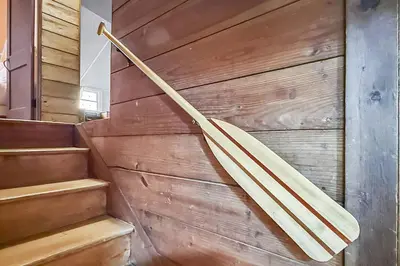 a wooden umbrella hanging on a wall next to stairs at Candlewood Isle in New Fairfield