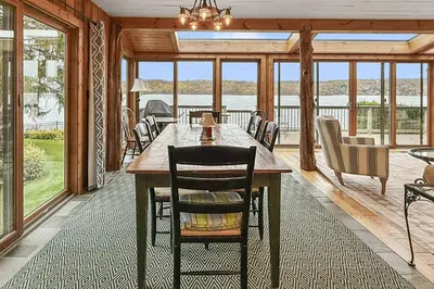 a dining room with a table and chairs and windows at Candlewood Isle in New Fairfield