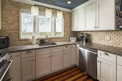 a kitchen with white cabinets and a sink at Pine Creek Beach House in Fairfield