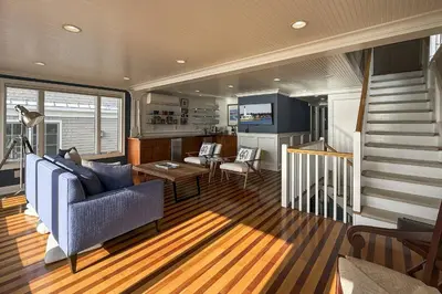 a living room with a blue couch and a staircase at Pine Creek Beach House in Fairfield