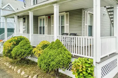 a white house with bushes on the front porch at Harbor Haven, Apt #2, 2 BR/1BA in Stamford