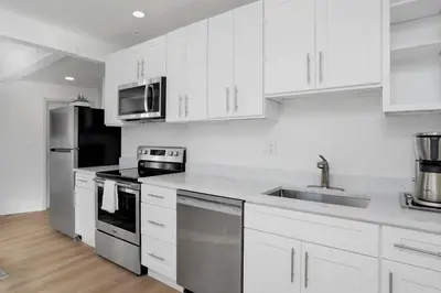 a kitchen with white cabinets and stainless steel appliances at Harbor Haven, Apt # 3, 3BR/2BA in Stamford
