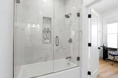 a white bathroom with a shower with a tub at Harbor Haven, Apt #5, 3BR/2BA in Stamford