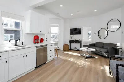 a kitchen and living room with white cabinets and a couch at Harbor Haven, Apt #5, 3BR/2BA in Stamford