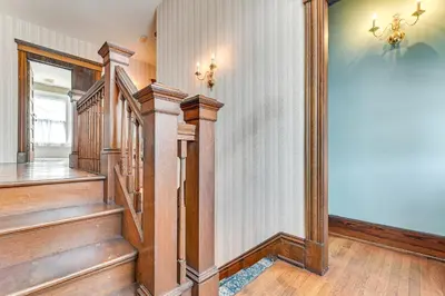 a hallway with wooden stairs in a home at Dedicated Workspace! Home 2 Mi to Dtwn Schenectady in Schenectady