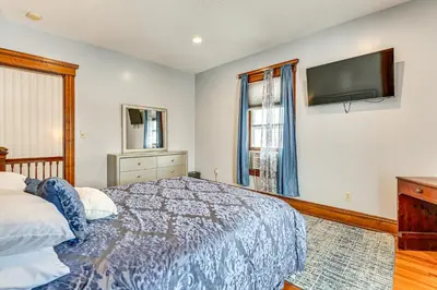 a bedroom with a bed and a flat screen tv at Dedicated Workspace! Home 2 Mi to Dtwn Schenectady in Schenectady