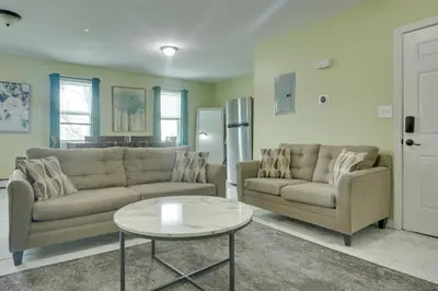 a living room with two couches and a table at Explore NYC, Parks and Beaches! Top-Floor Apt in Mount Vernon