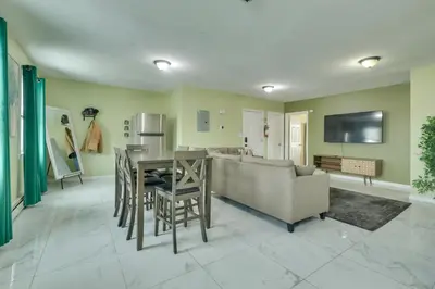 a kitchen and living room with a table and a couch at Explore NYC, Parks and Beaches! Top-Floor Apt in Mount Vernon
