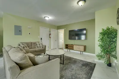 a living room with a couch and a table at Explore NYC, Parks and Beaches! Top-Floor Apt in Mount Vernon