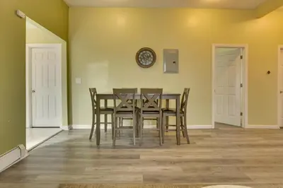 a dining room with a table and chairs and a clock at Easy NYC Access Updated Apt Near Parks and Bay! in Mount Vernon