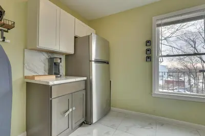 a kitchen with a refrigerator and a window at Easy NYC Access Updated Apt Near Parks and Bay! in Mount Vernon