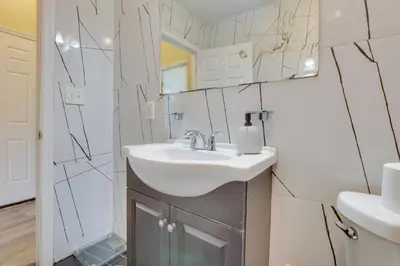 a bathroom with a sink and a mirror at Easy NYC Access Updated Apt Near Parks and Bay! in Mount Vernon