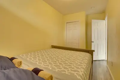 a bedroom with a bed and two white doors at Easy NYC Access Updated Apt Near Parks and Bay! in Mount Vernon