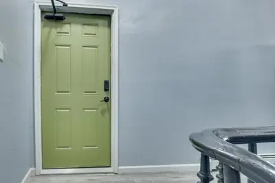 a green door in a room with a bench at Easy NYC Access Updated Apt Near Parks and Bay! in Mount Vernon