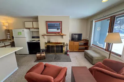 a living room with two chairs and a kitchen at Glen Run 2S in West Dover