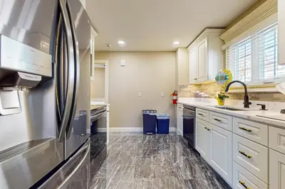 a kitchen with white cabinets and a stainless steel refrigerator at Centrally Located Home by Holyoke Medical Center in Holyoke