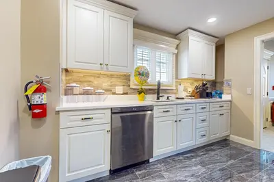 a kitchen with white cabinets and a stainless steel dishwasher at Centrally Located Home by Holyoke Medical Center in Holyoke