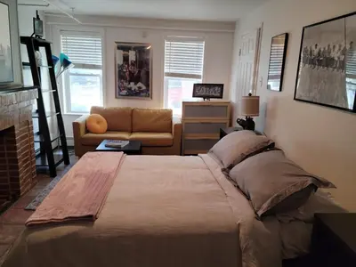 a bedroom with a large bed and a couch at The Cozy Flat near the Apple in Jersey City