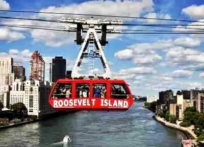 a red cable car flying over a river at 3 Bedroom Apt in LIC, 2 Stops to Manhattan! in Roosevelt Island