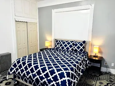 a bedroom with a blue and white bed and two lamps at 3 Bedroom Apt in LIC, 2 Stops to Manhattan! in Roosevelt Island