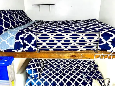 a bedroom with a bed with blue and white sheets at 3 Bedroom Apt in LIC, 2 Stops to Manhattan! in Roosevelt Island
