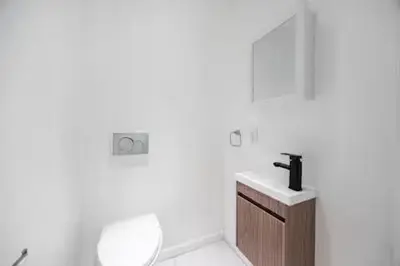 a white bathroom with a sink and a toilet at Bright Luxury 3-Bedroom Apartment in East Village in New York