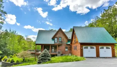 a log home with a green roof at Stunning 5BR at Hunter and Windham w Oversized Deck, 5 Acres, and Mountain View in Jewett