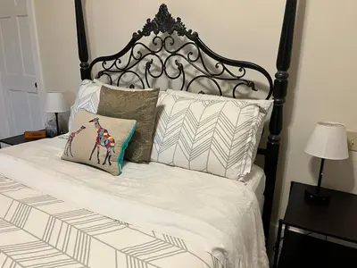 a bed with a black and white headboard and pillows at Stunning 5BR at Hunter and Windham w Oversized Deck, 5 Acres, and Mountain View in Jewett