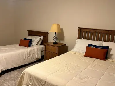 a bedroom with two beds and a lamp on a night stand at Stunning 5BR at Hunter and Windham w Oversized Deck, 5 Acres, and Mountain View in Jewett